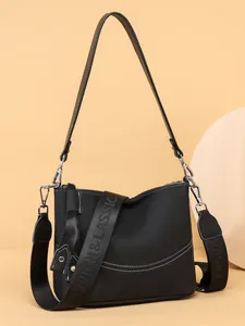 Minimalist black pebble leather crossbody bag with dual straps and silver hardware