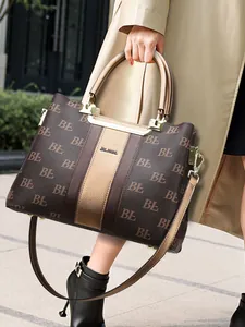 Retro brown monogram tote bag with top handle and crossbody strap in outdoor street setting