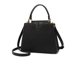 Close-up of black lychee grain leather texture with gold V logo and metallic hardware