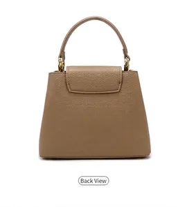 Back view of the pebbled leather bucket bag featuring a top handle and gold hardware