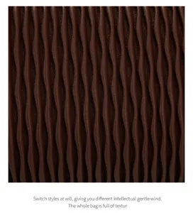 Macro shot of dark coffee brown handbag showing exquisite vertical wave pleated texture
