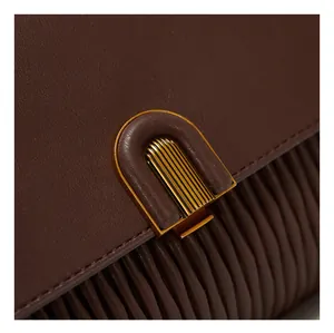 Detailed macro view of dark brown pleated leather texture with vintage gold metal buckle