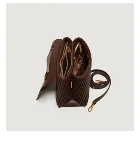 Interior view of brown pleated handbag showing multiple compartments and golden hardware