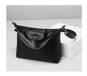 Detail of black matte leather tote bag featuring branded flap cover and zip closure