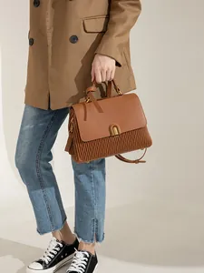 Fashionable caramel brown leather handbag with vertical pleats and golden U-shaped buckle