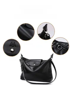 Detail view of black faux leather tote with M embossing and metal magnetic closure
