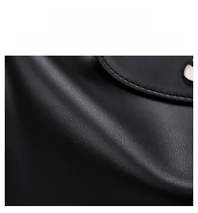 Macro detail of black textured leather tote bag showing scratch-resistant fabric surface