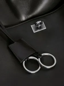 Vorderansicht einer schwarzen Leder-Tote-Bag mit silbernen Beschlägen im Architektur-Stil