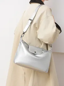 Detail of silver metallic tote bag with wide adjustable shoulder strap on female model