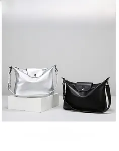 Detail view of silver and black PU leather tote bags with metal M logo and adjustable straps