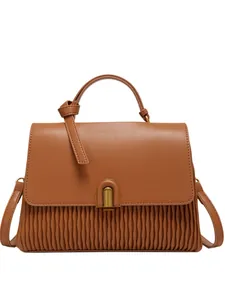 Brown pleated leather handbag with gold U-shaped lock and knotted handle on white background