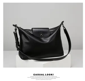 Detail of minimalist black leather tote bag featuring sleek flap cover and premium logo