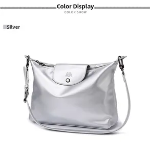 Detail of silver metallic tote bag featuring a prominent M logo and sleek gunmetal hardware