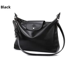 Close-up of black matte soft leather tote bag with silver hardware and embossed logo