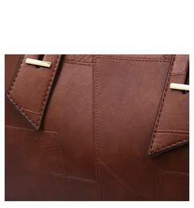 Close-up of brown litchi pattern leather tote bag with elegant gold metal hardware detail