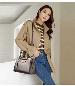 Model met een grote bronzen shopper met kangoeroe-logo en een verstelbare schouderriem