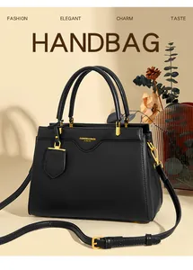 Close-up of black lychee grain leather texture and gold hardware on a luxury tote bag