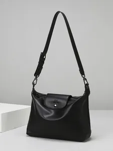 Minimalist black soft leather tote bag with flap closure and adjustable strap for women