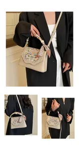 Detailed embroidery on beige crossbody bag with silk scarf handle and floral stitching