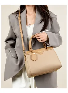 Close-up of khaki pebbled leather tote with detachable shoulder strap and metal base feet