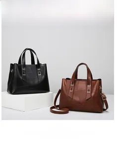 Detail view of large patchwork tote bag in black and brown with golden hardware