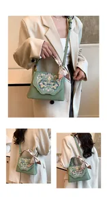 Detail of green crossbody bag featuring Chinese embroidery and silk scarf handle