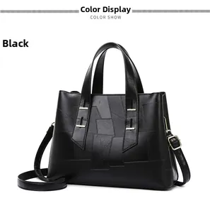 Detail view of black faux leather tote bag with unique patchwork and gold hardware