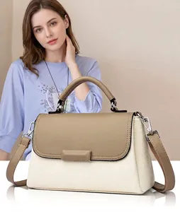 Detail van elegante tweekleurige crossbodytas van lychee-nerfleer met metalen handvat