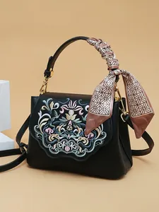 Black vintage embroidery crossbody bag with floral pattern and silk scarf handle detail