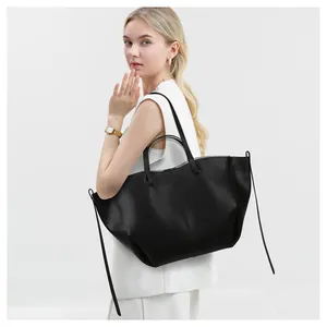 Bolso tote minimalista en cuero negro mostrado en una modelo para uso de oficina