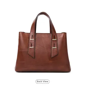 Detail view of the brown leather handbag back showing patchwork and gold metal hardware