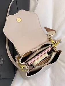 Crossbody bag with scallop flap and silk scarf handle showing spacious interior storage