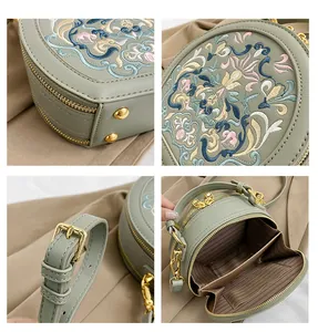 Macro details of green Chinese embroidery bag showing stitching and golden hardware