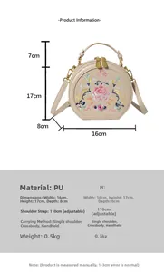 Detail view of round beige crossbody bag with pink floral embroidery and size specs