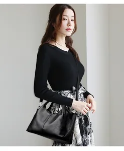 Aziatisch model met een minimalistische zwarte leren shopper voor dagelijks woon-werkverkeer