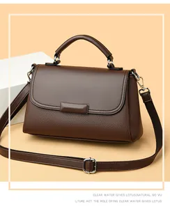 Detail van bruine leren crossbodytas met zilveren hardware en verstelbare schouderband