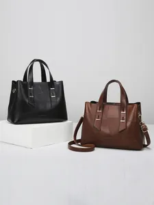 Black and brown geometric stitching tote bags with shoulder straps on display stands