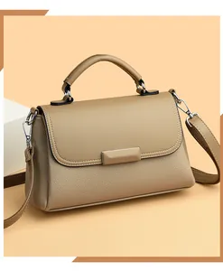 Detail van kaki kiezel lederen crossbody tas met lichtgouden gesp en handvat