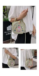 Detail of light green round crossbody bag featuring intricate floral embroidery and gold hardware