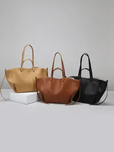 Bolsos tote grandes de cuero minimalistas en negro, marrón y canela con estructura de alas
