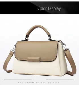 Detail van tweekleurige beige en camel handtas met zilveren gesp en stevig handvat