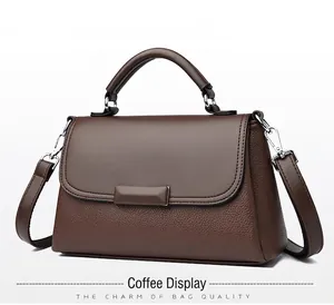 Detail van de koffiebruine crossbody tas met litchi textuur en een metalen gesp
