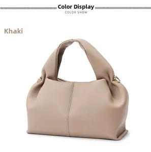 Close-up of khaki cloud bag showing soft lychee grain leather and gold metal rings