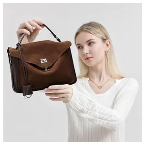 Detail of dark brown frosted suede messenger bag with silver metal twist lock closure