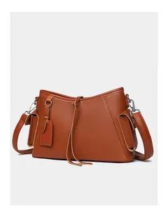Detail of brown lychee grain leather shoulder bag featuring side flap pockets and silver hardware