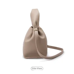 Side view detail of taupe leather cloud handbag with ruched handle and gold hardware