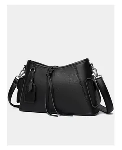 Detailed view of black litchi texture leather shoulder bag with side flap pockets and silver hardware