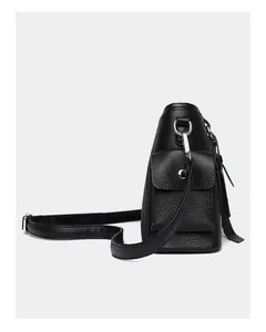 Detail of black pebbled leather texture with silver metal hook and side pocket on the bag