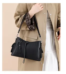 Detail of black pebbled leather shoulder bag with side flap pocket and silver hardware