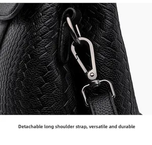 Detail of detachable shoulder strap with silver metal buckle on woven texture handbag